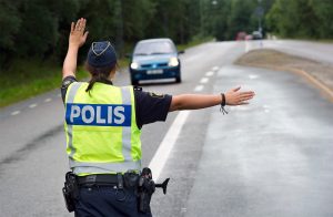 Poliskontroll: kvinnlig trafikpolis vinkar in bil